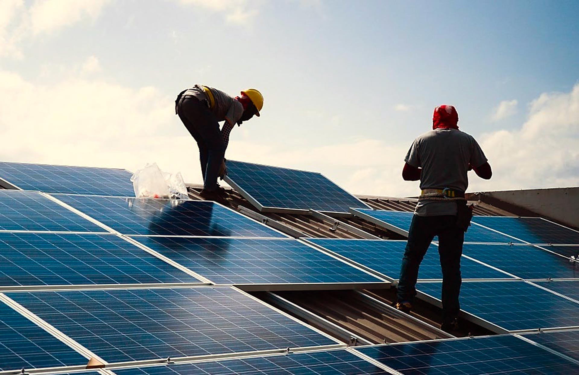 techniciens installant des panneaux solaires sur une toiture
