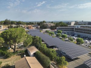 Vue aérienne d’ombrières solaires sur un parking de clinique, qui produisent une partie de l’électricité consommée sur place